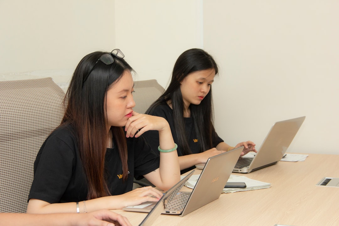 Women collaborating with laptops in a modern office